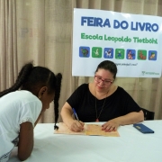 Escritora Ana Maria Bettini, autora do livro " O Gatinho preto", distribuindo autógrafos para os alunos