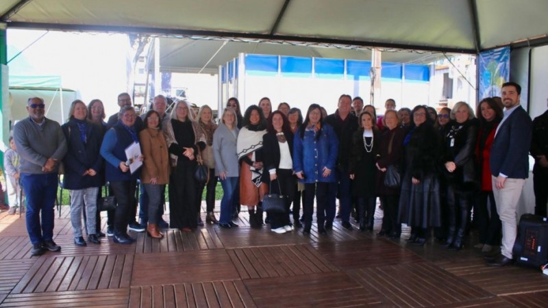 Foto retirada no estante do Instituto Rio Grandense do Arroz (IRGA), na Fenarroz, em Cachoeira do Sul. A imagem mostra um grupo de pessoas, incluindo a Secretaria de Educação, Raquel Teixeira, comemorando a assinatura do termo de compromisso