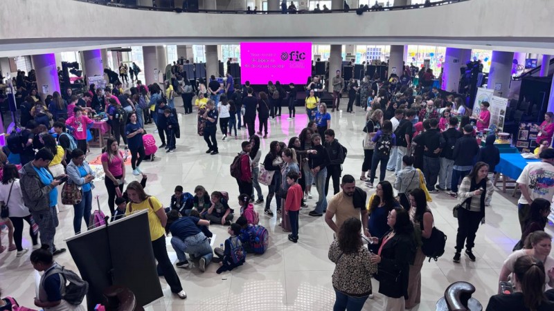 Foto do salão principal do Instituto Federal de Educação, mostrando um saguão amplo com diversas pessoas circulando entre estandes de estudantes.