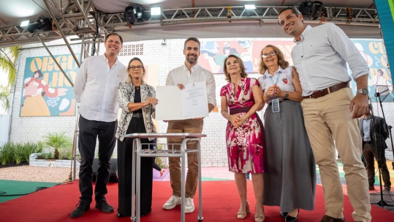 Foto possada em que Leite e outras pessoas mostram o documento recém assinado.